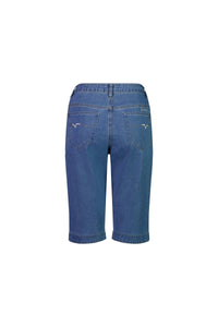 Back view of Vassalli Custom Short - Light Denim, showing stretch denim in a straight-leg cut with two back pockets, visible stitching, and a small embroidered logo on the right pocket against a white background.